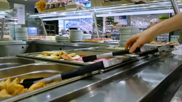 女性はセルフ サービスのレストランで皿に揚げたパテを置く — ストック動画