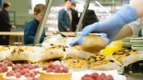 Cocinero está poniendo productos frescos horneados en el escaparate en el restaurante de catering público en el fondo de la cola — Vídeos de Stock