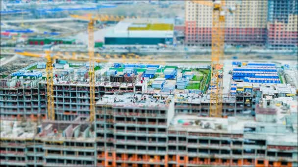 Bâtisseurs et grues à bascule temporel travaillant sur le chantier de construction — Video