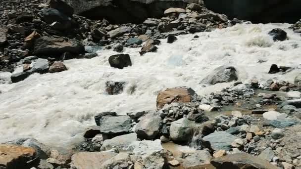 Mountain river flows out from under the glacier, a beautiful panoramic landscape, slow motion. Group of tourists on excursions, camera movement — Stock Video