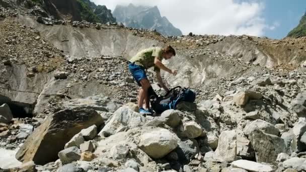 Turistik bir sırt çantası toplar ve kendi üzerine koyar — Stok video