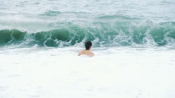 Gran ola de mar cubre a un hombre feliz bañado en una tormenta en el mar — Vídeos de Stock