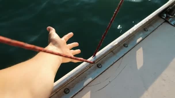 Manlig hand sträcker sig till vågorna på en yacht närbild — Stockvideo