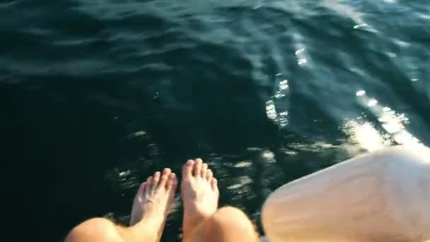 Männerbeine und ein Kotflügel, der von einer Jacht im Meer baumelt, segeln mit hoher Geschwindigkeit — Stockvideo