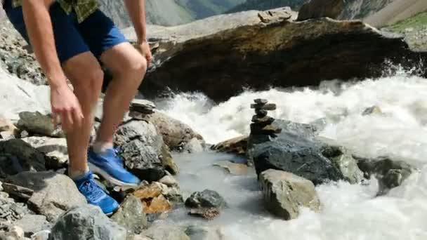 L'homme touristique boit l'eau des palmiers d'une rivière de montagne tout près — Video