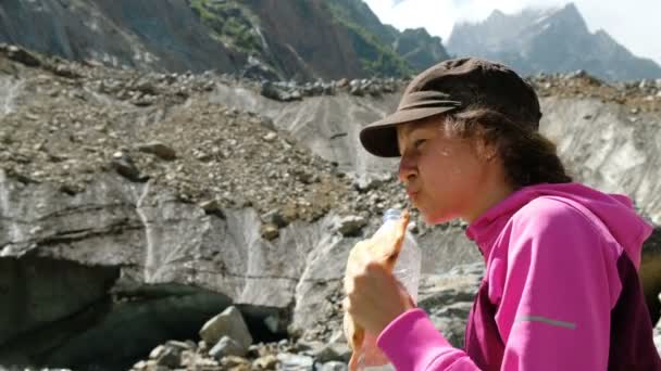 Femme boit de l'eau touristique et mange du pain dans les montagnes fermer — Video