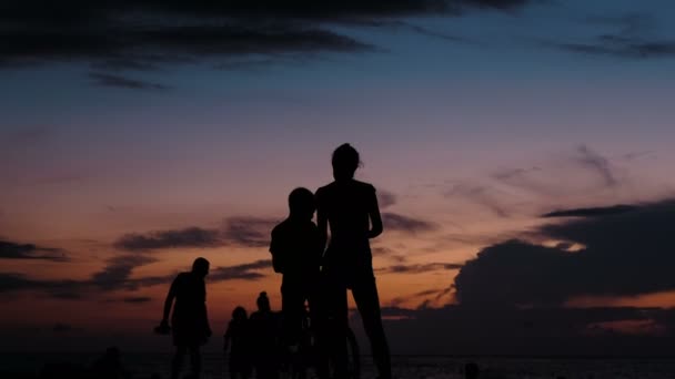 Silhuetten av turist fotograferar på smartphone solnedgången vid havet — Stockvideo