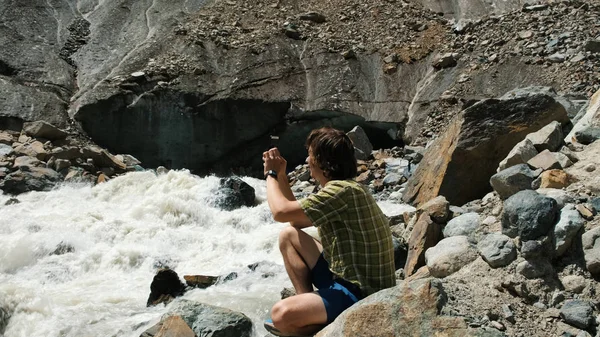 Las fotografías de hombre en el paisaje de smartphone - el río montañoso, el glaciar — Foto de Stock