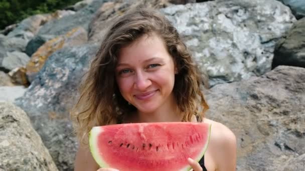 Retrato de uma mulher com uma fatia de melancia nas mãos, sorrindo para a câmera — Vídeo de Stock