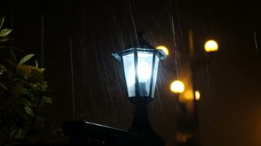 Yağmur damlaları sokak lambası vurmak, su yakın çekim ışığı yanar