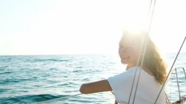 Elbiseli güverte üzerinde oturan ve açık denize bakarak mutlu kız