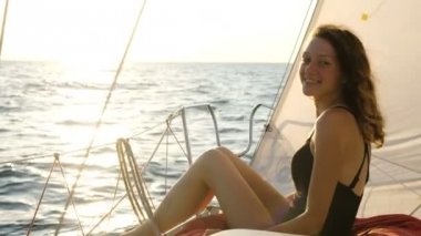 Deniz yay üzerinde bir yatta yelken bir mayo içinde bir kadın portresi