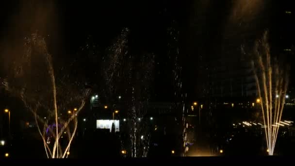 Fuentes danzantes y salpicaduras de agua por la noche en la ciudad. Luces, colores y espectáculo nocturno de música — Vídeo de stock