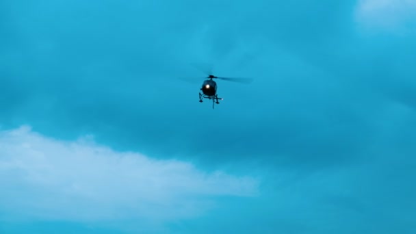 Helicopter takes off and flies away the clouds of clouds — Stock Video