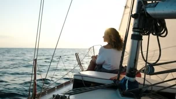 Mladá dívka v šatech sedí na palubě plachetnice blízko stožáru — Stock video