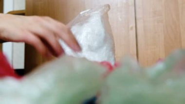 Çok renkli plastik torba geri dönüşüm için sıralama bir el şeffaf plastik torbalar toplar.