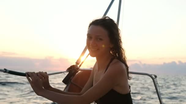 Retrato de mujer feliz en traje de baño en un yate y disfrutando de una vista al mar al atardecer — Vídeos de Stock