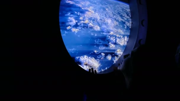 Женщина смотрит в иллюминатор в космосе — стоковое видео