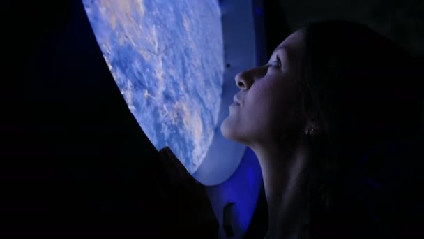 Девушка смотрит в окно на МКС — стоковое видео