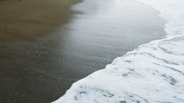 Onde con schiuma di mare lentamente versare attraverso la sabbia sulla spiaggia, 4k — Video Stock