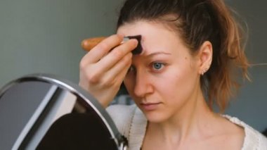 Güzel kız makyaj bir ayna önünde yok etmiş, bir toz balina, 4 k