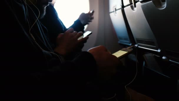 Les passagers utilisent des téléphones dans l'avion en vol, se concentrent sur différentes mains — Video