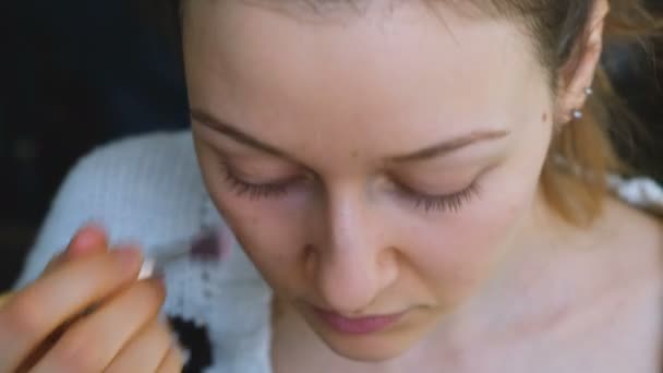 La belle fille couvre les ecchymoses sous les yeux avec un correcteur minéral gros plan, 4k — Video