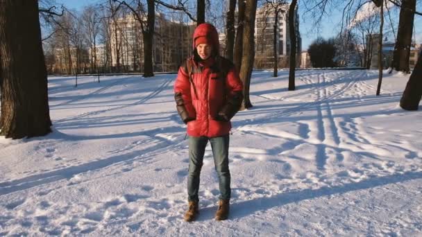 L'homme gèle dans le parc en hiver, passe du pied au pied, ralentit — Video