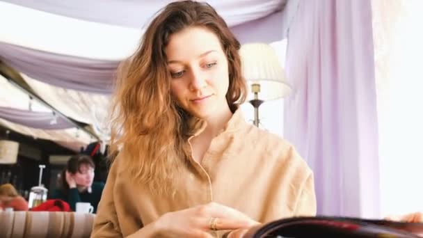 Hermosa chica joven estudiando el menú en un restaurante japonés — Vídeos de Stock