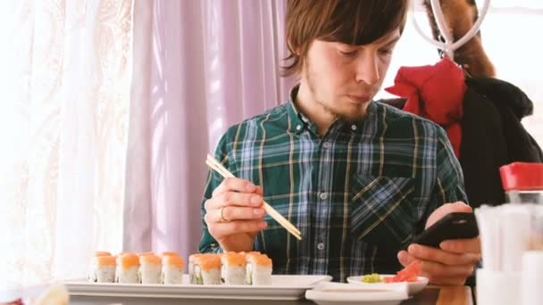 Mann Isst Brötchen Mit Brötchen Und Schaut Restaurant Aufs Telefon — Stockvideo