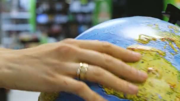Mulher gira o globo em uma loja — Vídeo de Stock