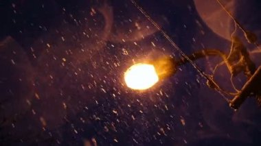 Gece şehirde, ağır çekim bir sokak lambası arka planı kar düşüyor