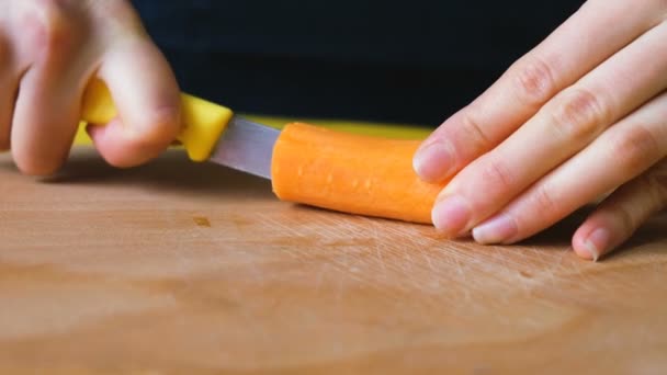 Mulher cortou cenouras em fatias em uma tábua de corte — Vídeo de Stock