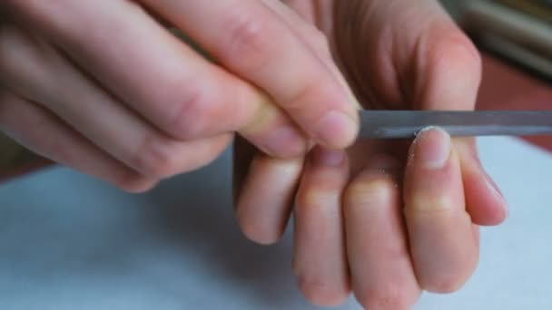 Woman is making herself a manicure close-up, girl is peeling her nails — Stock Video