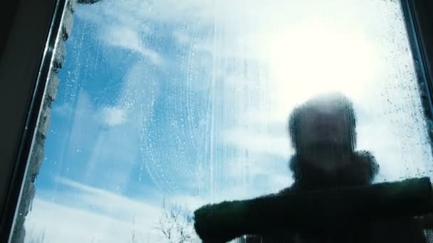 Man lathers het vuile venster van zichzelf thuis op de balkon-close-up — Stockvideo