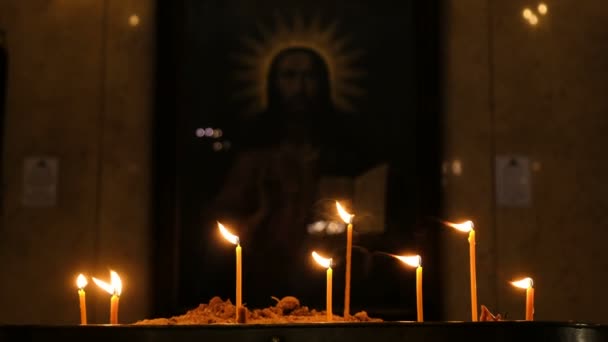 Velas estão queimando na antiga igreja cristã no escuro. Religião e tradições — Vídeo de Stock