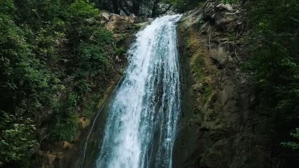 Großer Wasserfall fließt eine Klippe hinunter in einem Park, Zeitlupe — Stockvideo