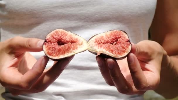 Woman holds figs in half open closeup in nature in summer — Stock Video