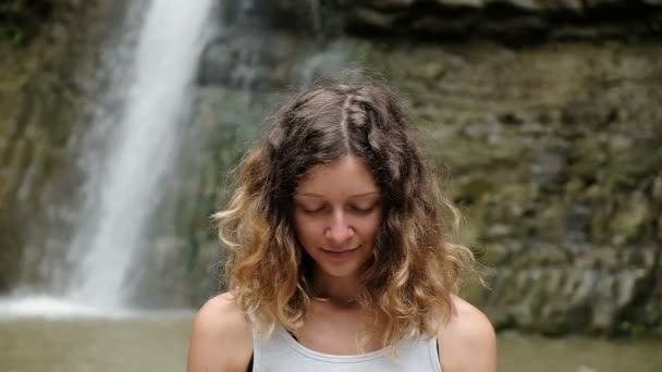 Happy girl meditates and opens her eyes while awakening from the practice, slow motion — Stock Video