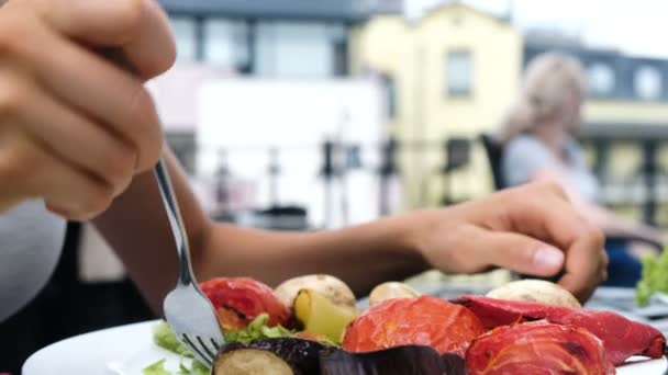 Mujer comiendo un tenedor con verduras a la parrilla con ensalada fresca primer plano en el verano al aire libre — Vídeos de Stock