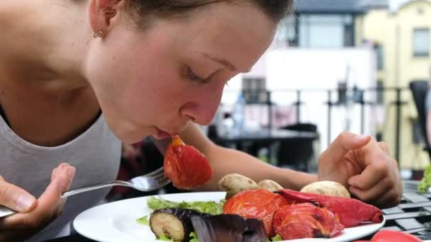 Τουριστική γυναίκα τρώει λαχανικά σχάρας με ένα πιρούνι με μια φρέσκια σαλάτα γκρο πλαν — Αρχείο Βίντεο