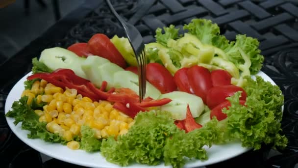 Mujer toma un tenedor con pimienta fresca, pepino y tomate con plato de verduras de cerca — Vídeos de Stock