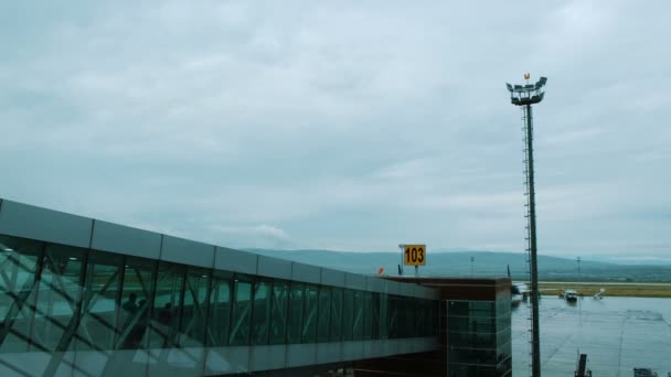 Grupo de turistas camina a lo largo de la terminal a un corredor transparente para abordar un avión — Vídeo de stock