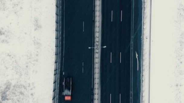 Aerial view vertically down the highway in winter, cars drive along the road — Stock Video