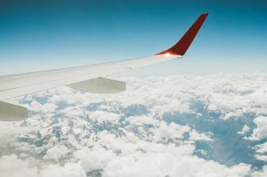 Bir uçağın dağlar yukarıda gökyüzünde kanat