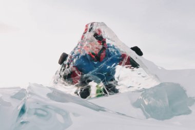 A man looks through a transparent ice on Lake Baikal clipart