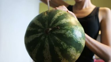 Kadın karpuz mutfakta iki parçaya bıçakla keser