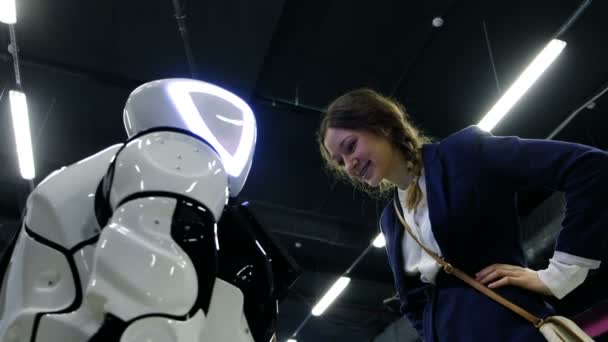 San Petersburgo, Rusia - 12 de noviembre de 2018: Joven chica hermosa leyendo una pantalla de robot promocional y hablando con un robot — Vídeos de Stock