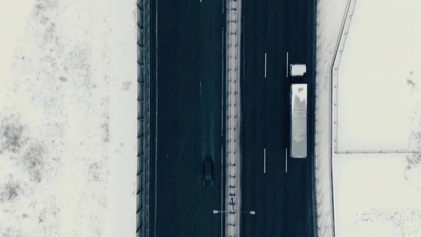 Vista aérea verticalmente para baixo da estrada no inverno, carros dirigem ao longo da estrada — Fotografia de Stock