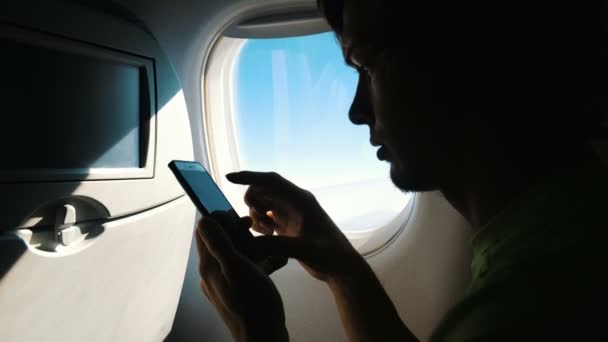 Άνθρωπος τουριστική περιήγηση κινητό τηλέφωνο αγγίζουν οθόνης εν πλω αεροπλάνο στο ταξίδι — Αρχείο Βίντεο